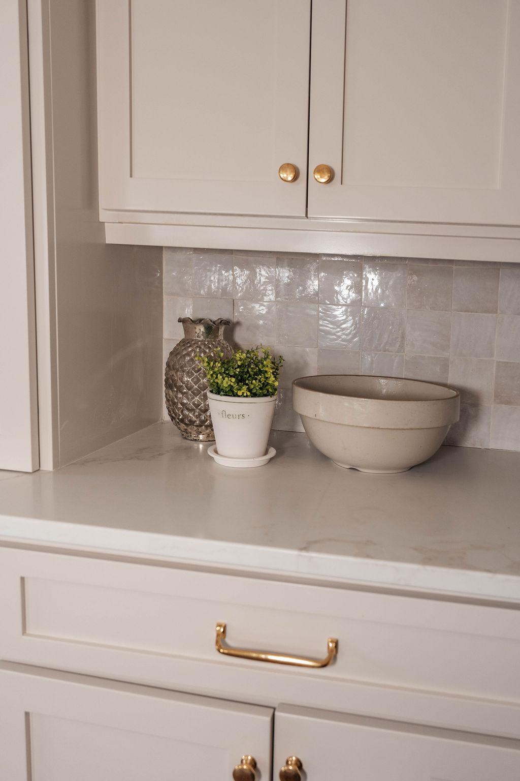Glazed tile, brass hardware, and ceramics in a Windy Peak kitchen detail by Middle West Studio